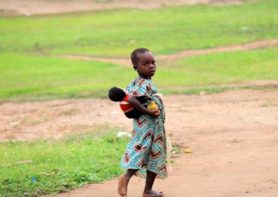 Little girl copies mummy carrying her doll on her back